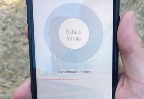 Image of a veteran using mobile phone app for mindful breathing