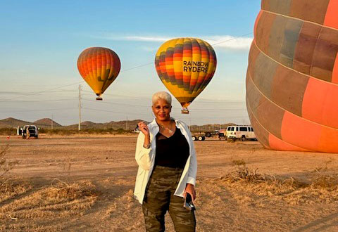 woman posing next to hot air balloons