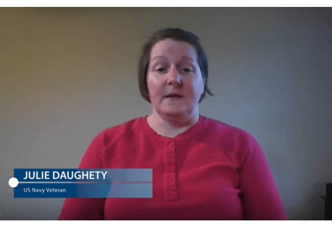 Woman in red shirt speaking to camera with name displayed Julie Daughety Navy Veteran