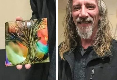 man holding a piece of art his painting