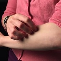A person touching their forearm with their opposite hand.
