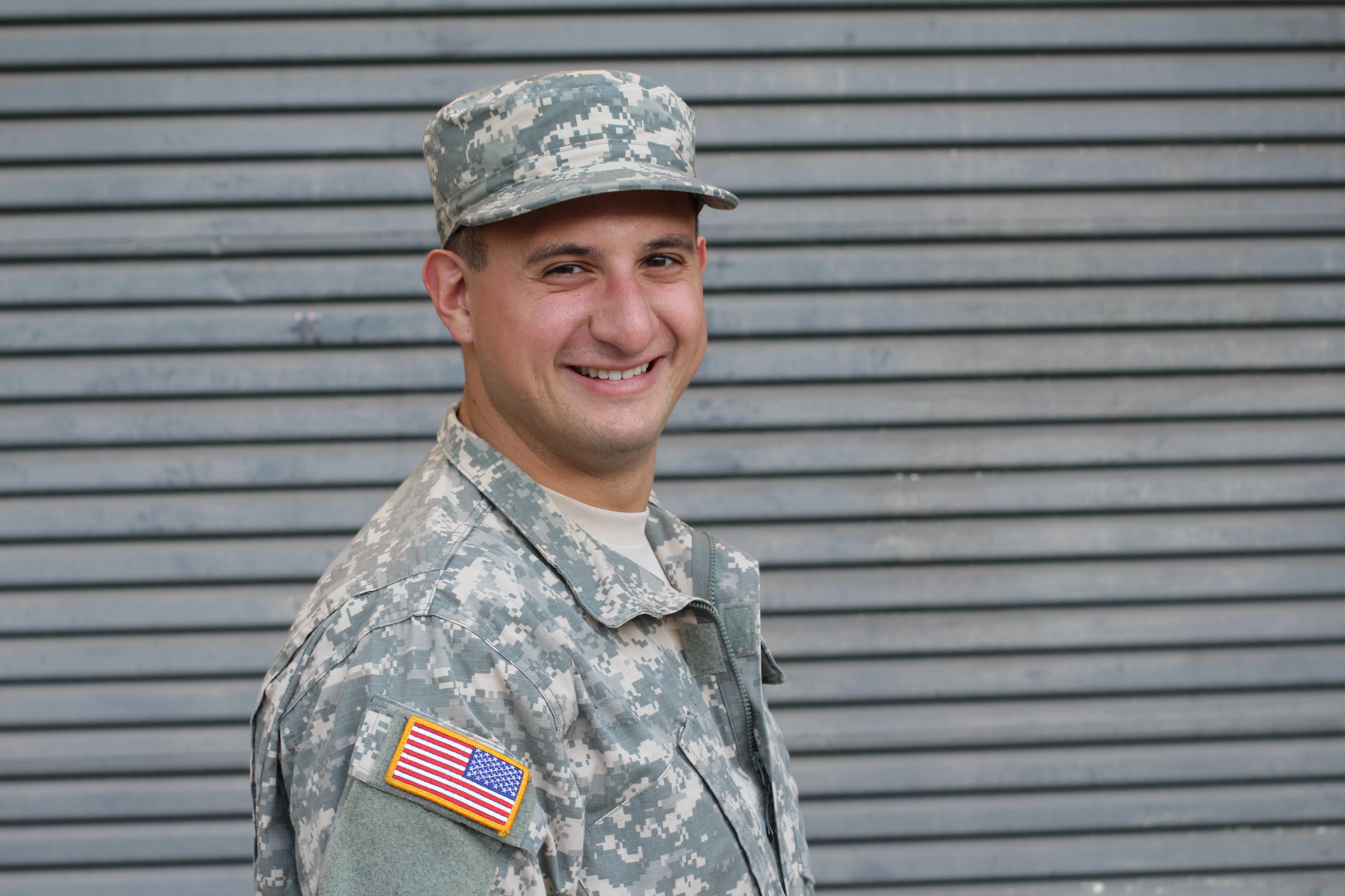 Close-up of a smiling male soldier in army fatigues.