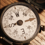 A close up picture of a compass on a desk.