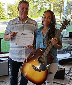 Guitars for Vets instructor Robert Grealy and D’Andrea Jacobs, CMV Program Analyst at a G4V Open Mic Graduation Ceremony