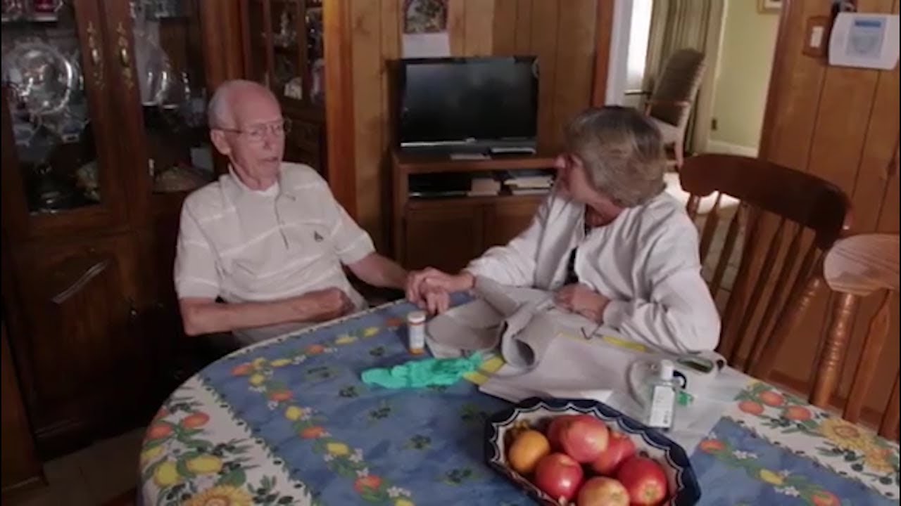 an older couple talking a the kitchen table