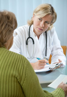 Physician at desk consulting a patient.