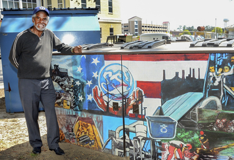 Vetran Charles Yeager standing next to one of his award winning murals