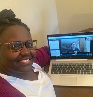 Yvonna Beckford at computer with Christine Tipanero appearing in video onscreen