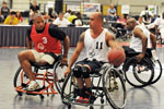 An athlete in a wheelchair dribbles the ball during a basketball game.