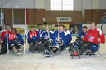 Hockey players in assistive skating gear pose for a group photo.