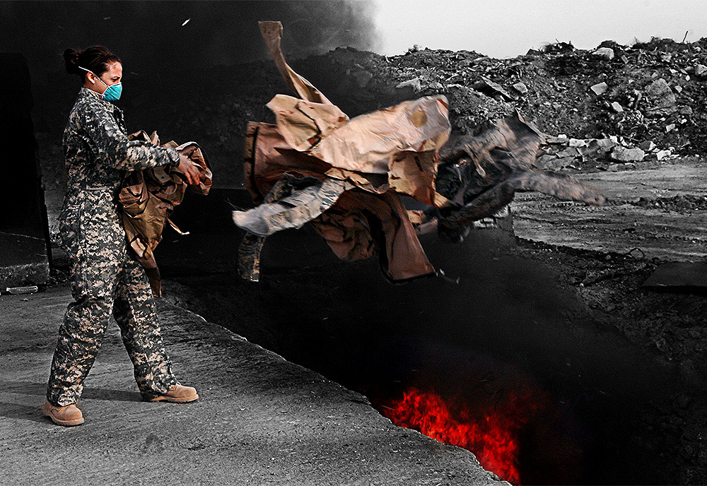Soldier throwing waste in burn pit. Soldier throwing waste in burn pit.
